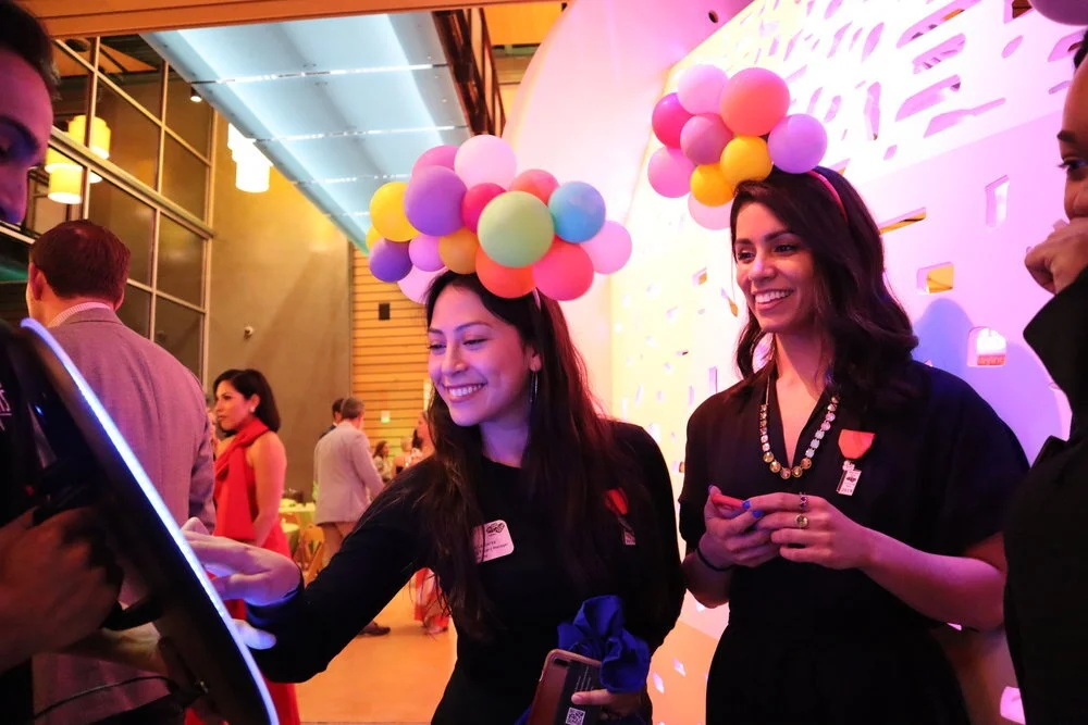 Guests viewing their photos on a roaming photo booth at a colorful event