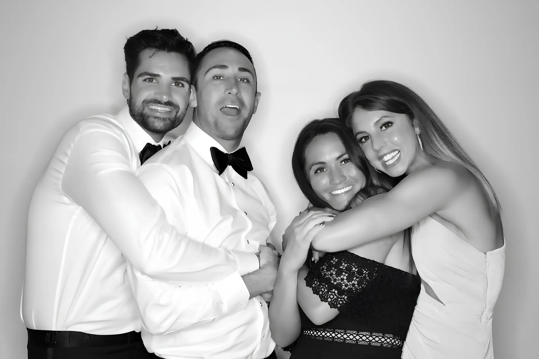 Two couples being playful in a black and white Glam Booth photo