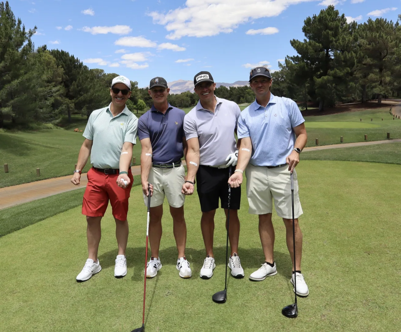 Foursome on the tee box at a golf tournament